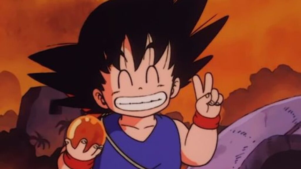 Goku faisant le signe de la victoire tout en tenant une boule de cristal dans sa main dans l'anime Dragon Ball